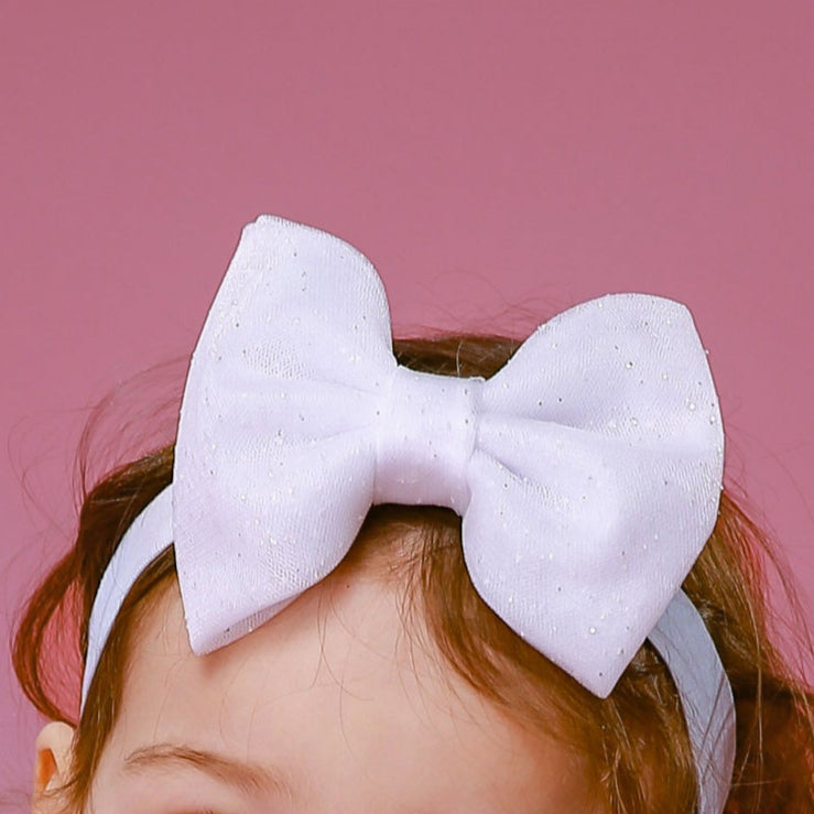 Elastisches Haarband mit Schleife aus Glitzerüll in weiß. Sowie ein festliches Mädchnkleid aus atin und Tüll in weiß