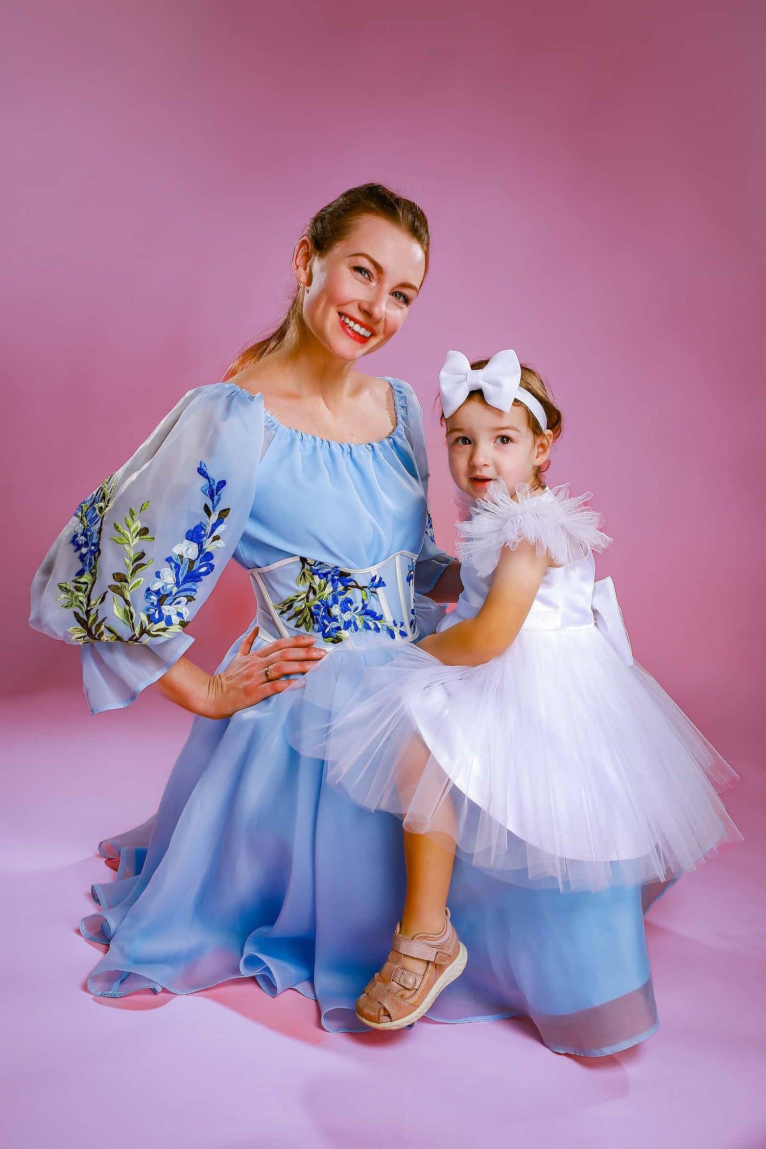 Designerin im Atelier de Couture Nataliia gemeinsam mit einem festlich gekleideten Mädchen, handgefertigte Mädchenkleider für besondere Anlässe