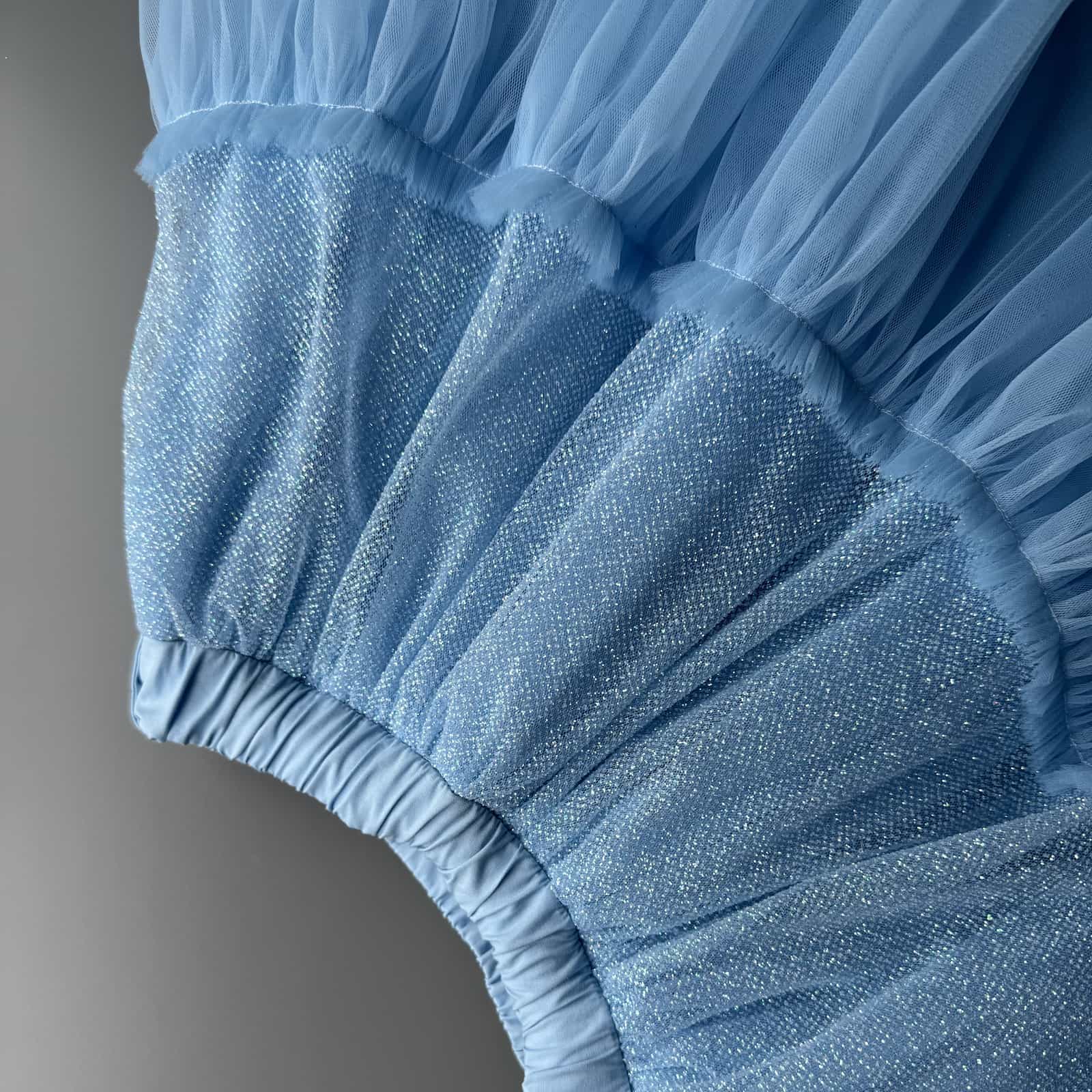 Close-up detail of blue glitter tulle skirt fabric for girls with soft sparkling layers and tulle texture