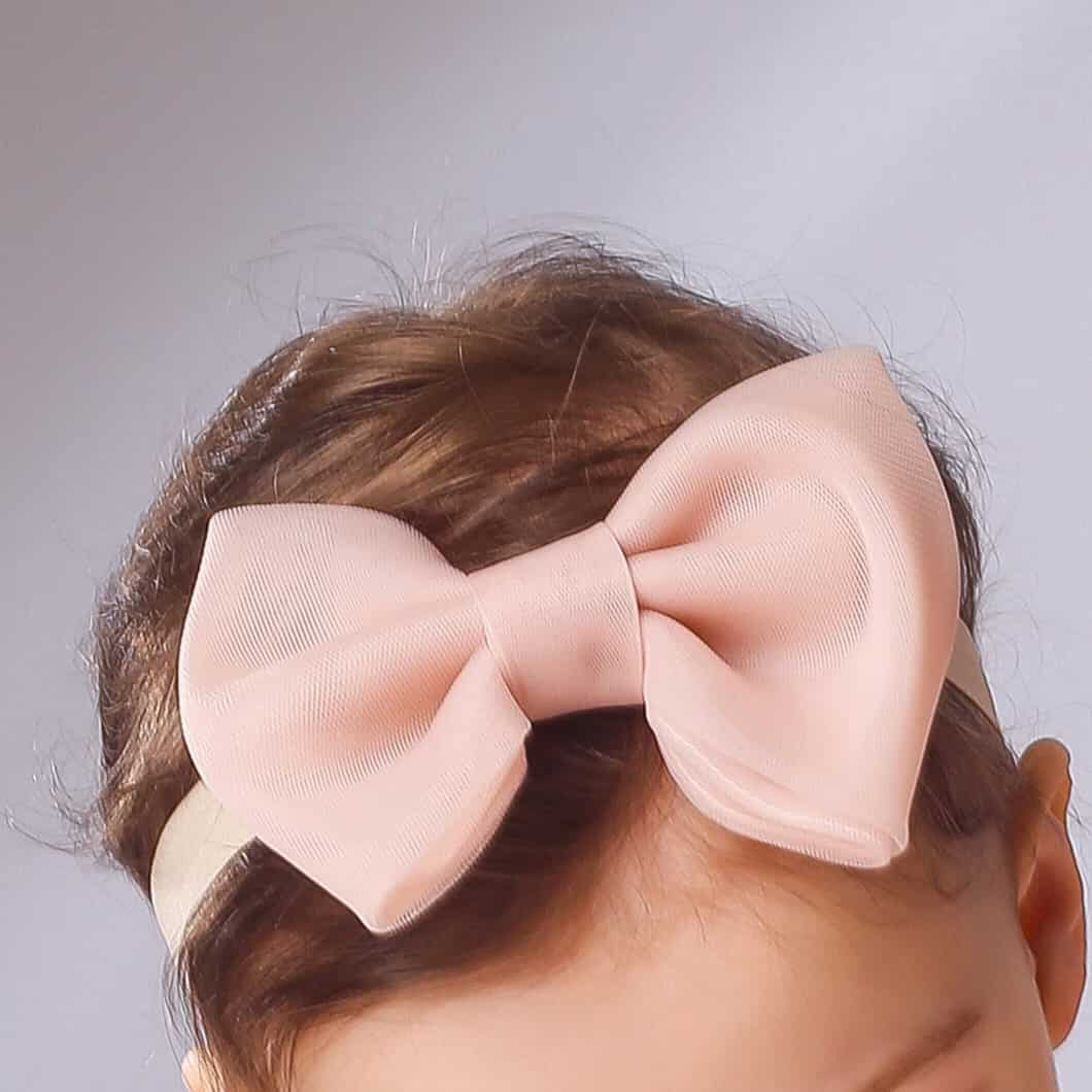 Close-up of blush pink tulle hair bow for girls – handmade elastic hair accessory for babies and toddlers