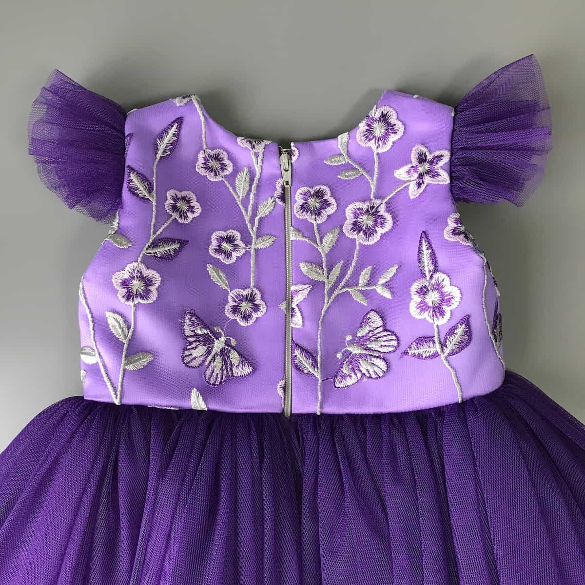 Detailansicht Reißverschluss am festlichen Kinderkleid in Lila, hochwertige Verarbeitung und Rückenteil mit Spitze