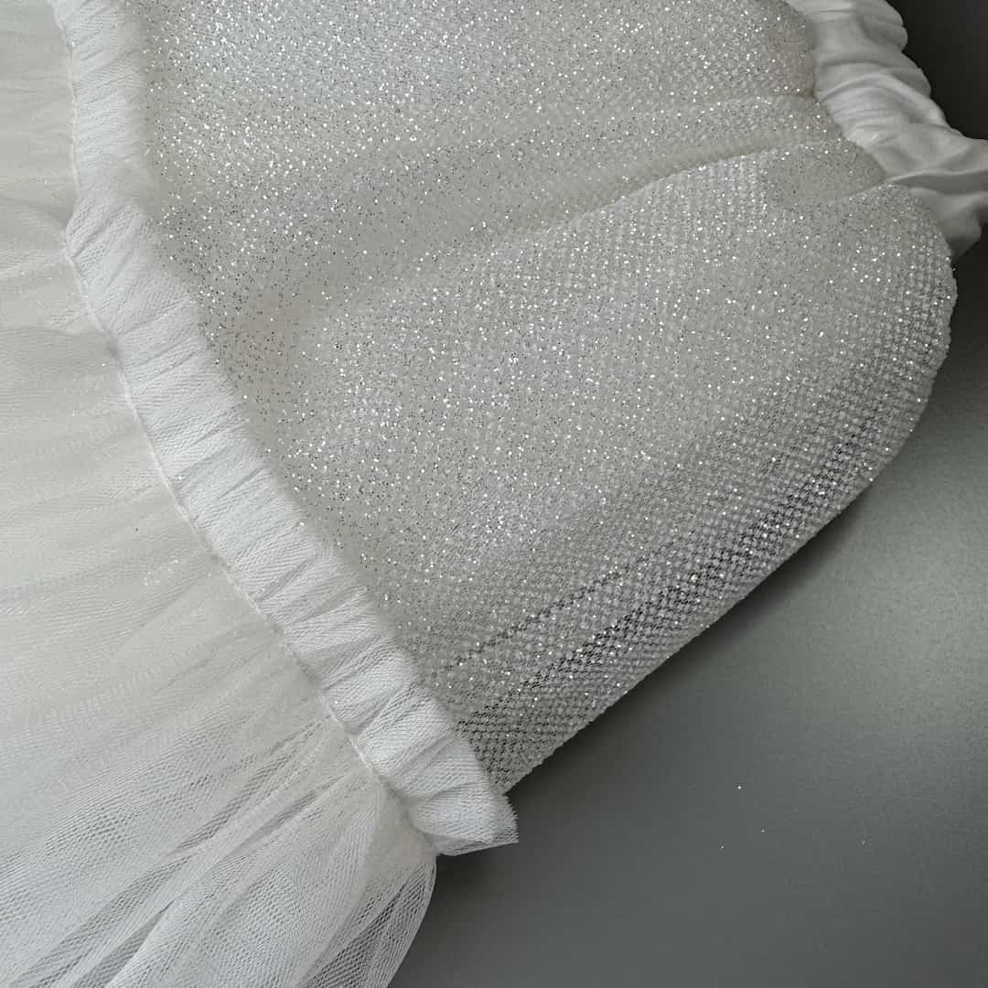 Close-up detail of offwhite glitter tulle skirt fabric for girls with soft sparkling layers