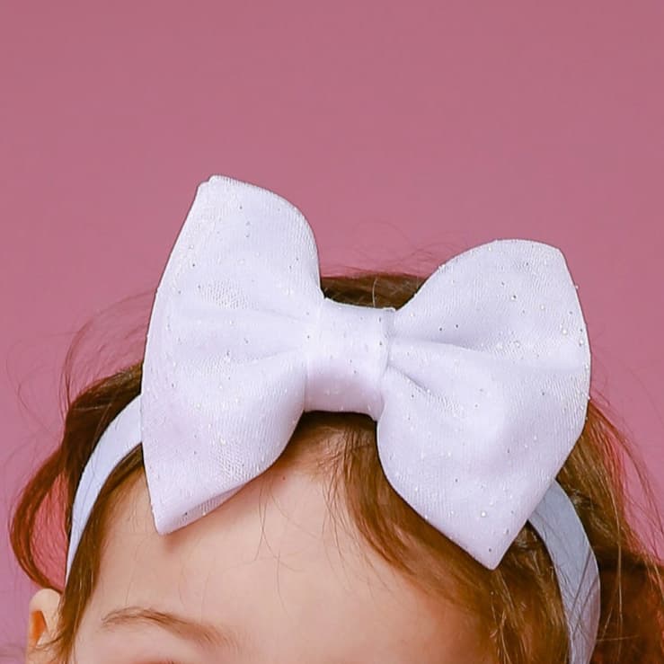 Close-up of white glitter tulle hair bow for girls – elegant handmade hair accessory for festive occasions